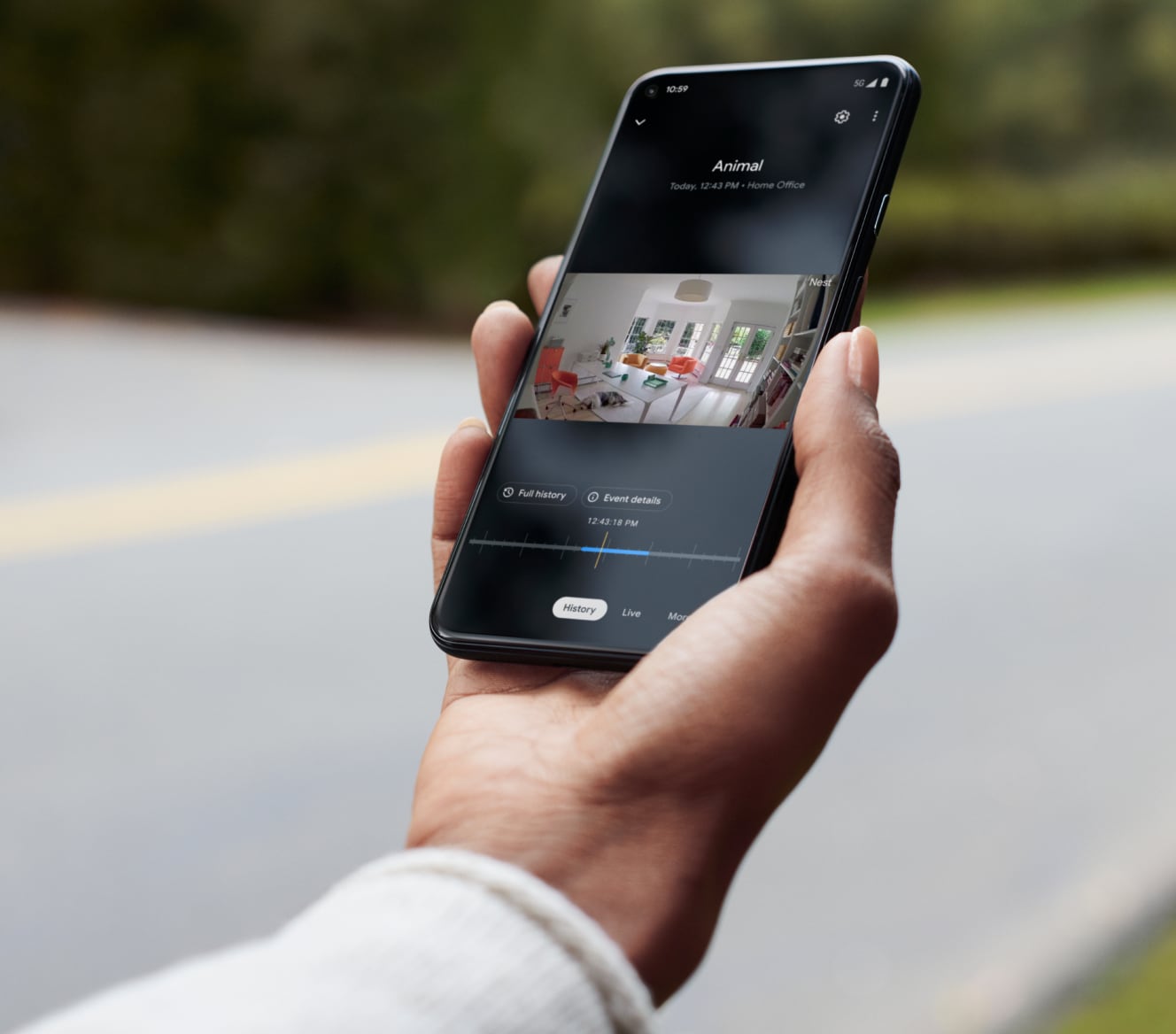 Hand holding a cell phone showing footage from his Google Nest Cam Hand holding a cell phone showing footage from his Google Nest Cam