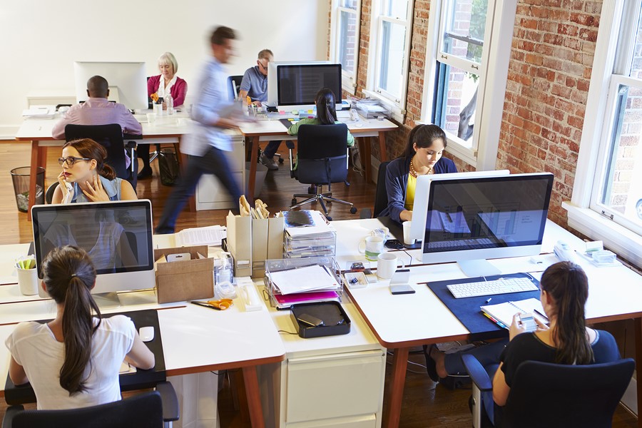 Businesses rely on the cloud for data storage more and more, despite cloud computing threats and vulnerabilities. How can you be sure of cloud security? Wide Angle View Of Busy Design Office With Workers At Desks