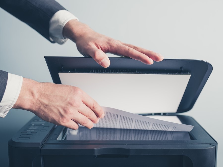 There are more reasons than ever for business owners to digitize documents that need extra protection, but how can they carry out the process securely? Hands Of Businessman Copying Document