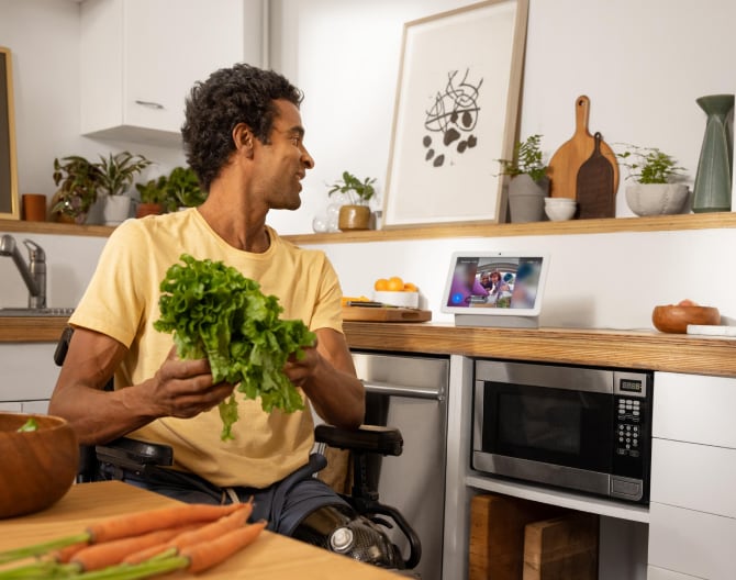 Man using his Google Nest Hub Max to see his live Google Nest Cam footage Man using his Google Nest Hub Max to see his live Google Nest Cam footage