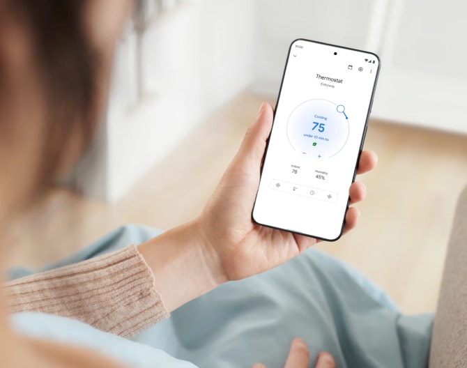 Woman adjusting her Google Nest Learning Thermostat using her cell phone Woman adjusting her Google Nest Learning Thermostat using her cell phone