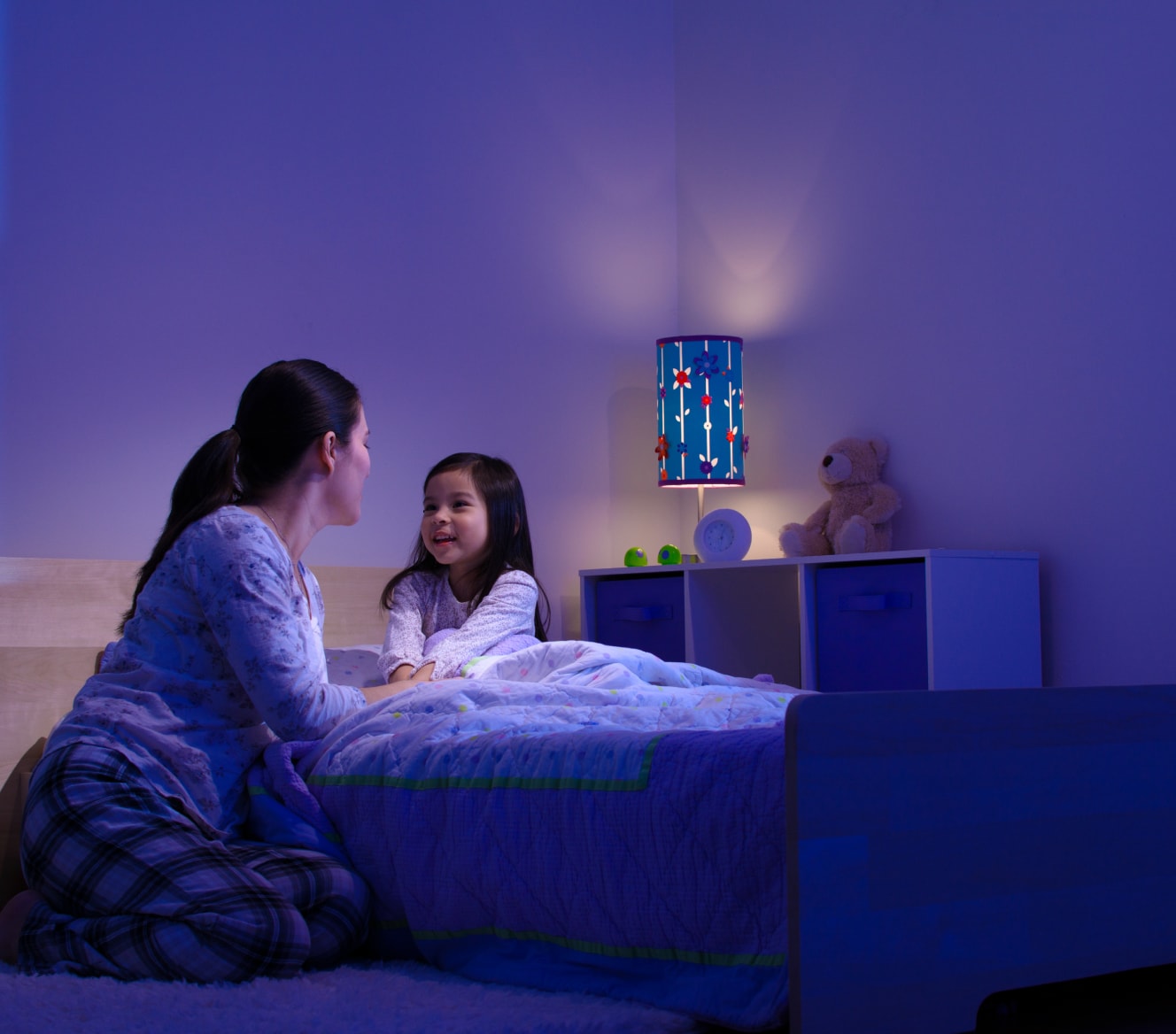 Women tucking in her child while the Google Nest Learning Thermostat sets the temperature Women tucking in her child while the Google Nest Learning Thermostat sets the temperature