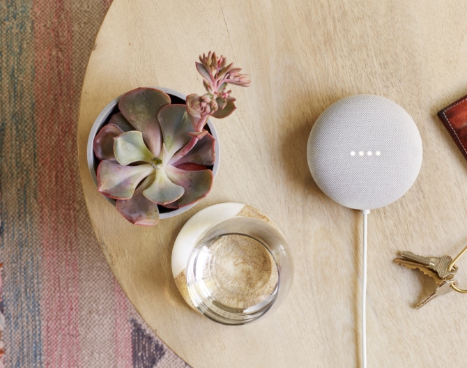 Google Nest Mini on a table with succulent and house keys Google Nest Mini on a table with succulent and house keys