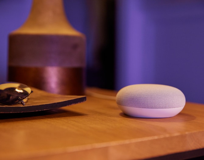 Google Nest Mini on a bedside table Google Nest Mini on a bedside table