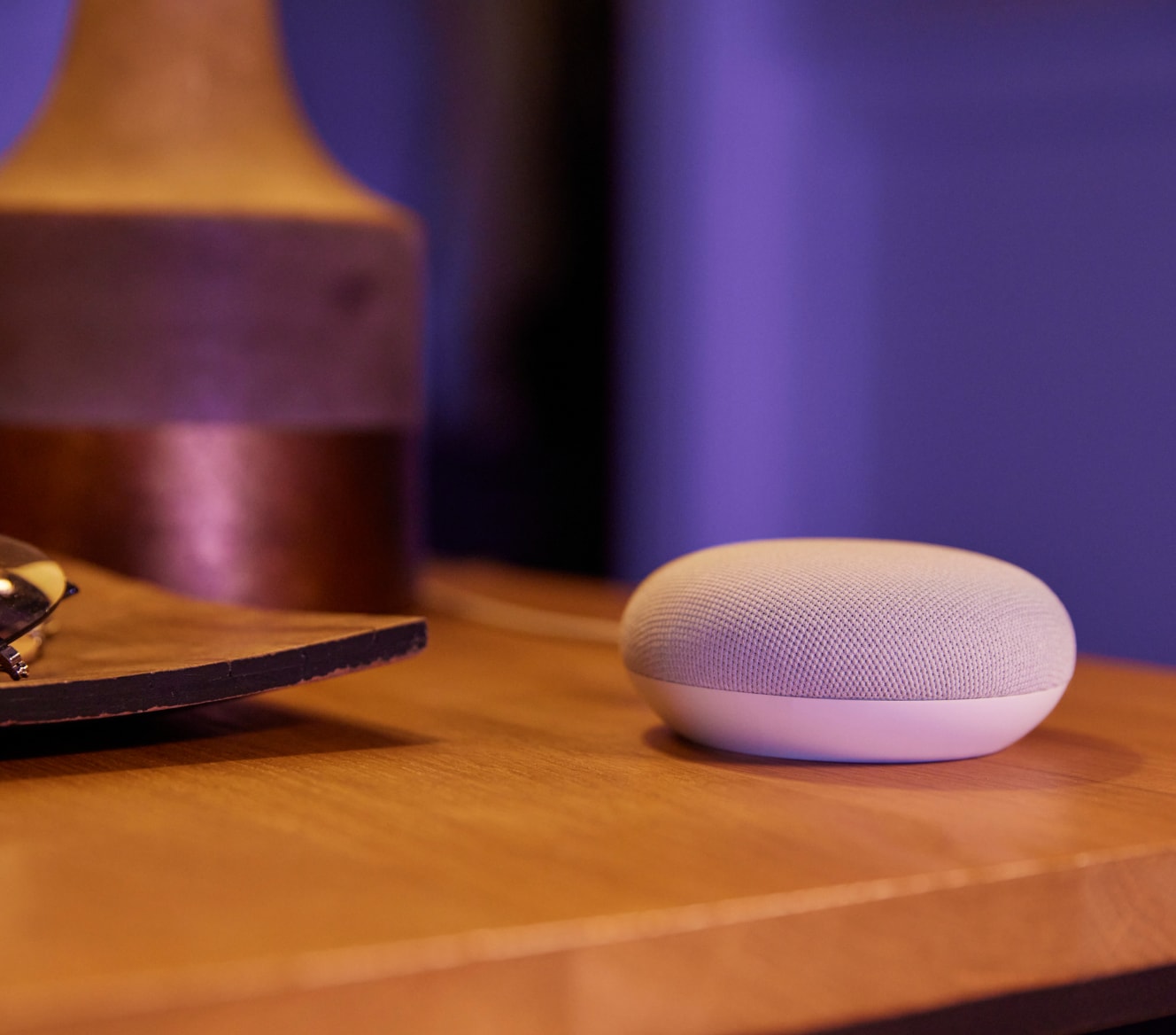 Google Nest Mini on a bedside table Google Nest Mini on a bedside table