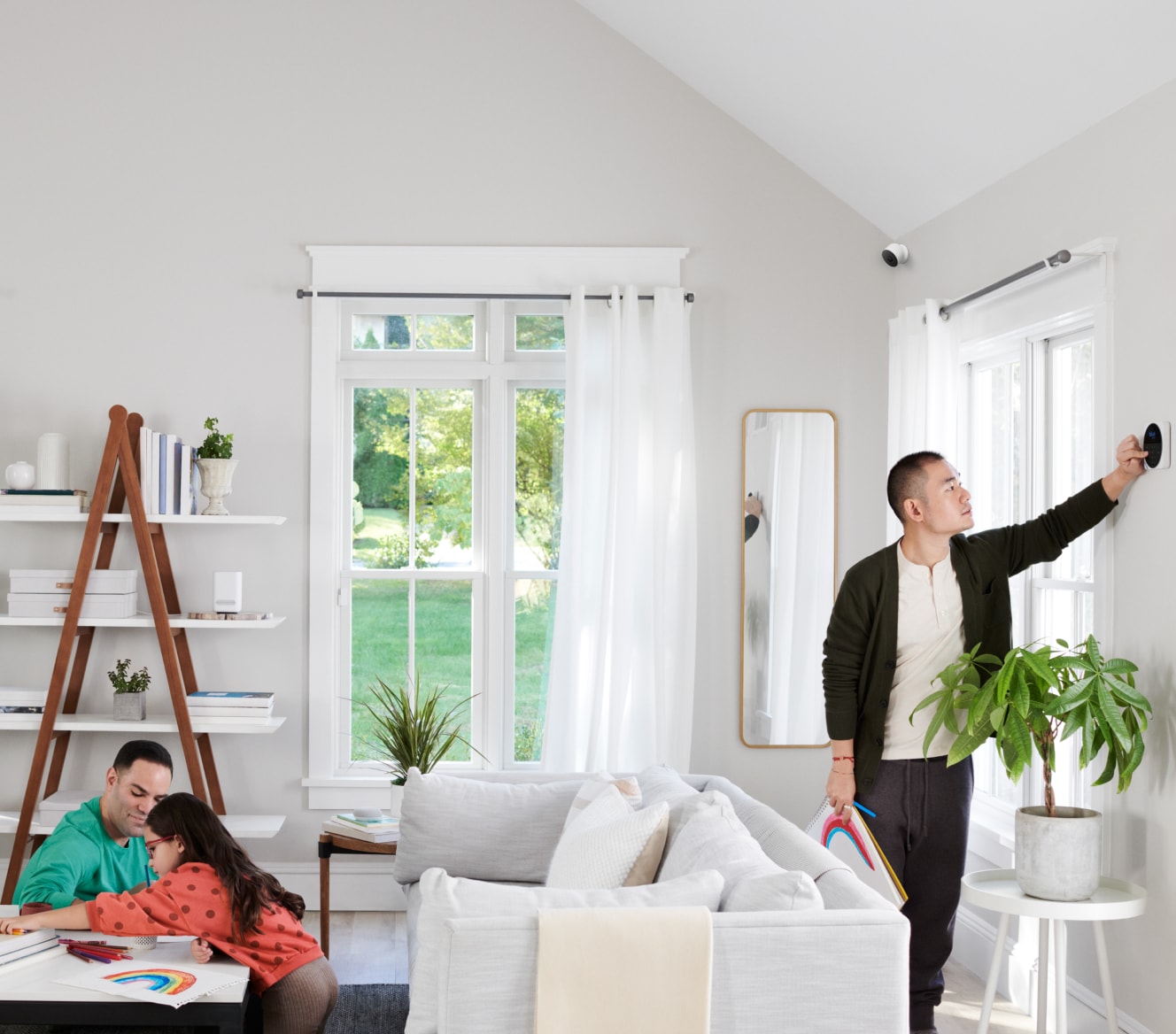 Google Nest Cam installed in a living room where a family is coloring together Google Nest Cam installed in a living room where a family is coloring together