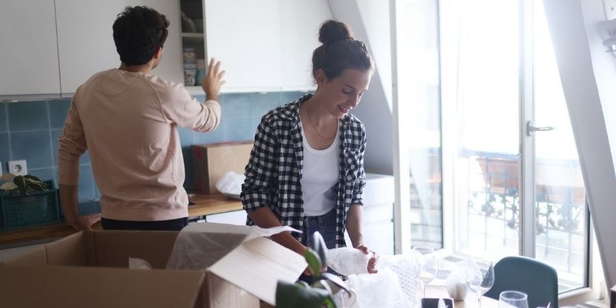 How to Load a Moving Truck Like an Expert A couple in their kitchen packing up to move