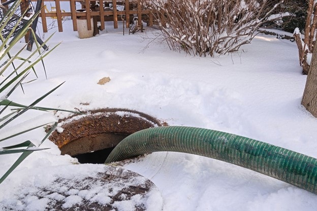 Hose going into a septic tank on a snowy day Hose going into a septic tank on a snowy day