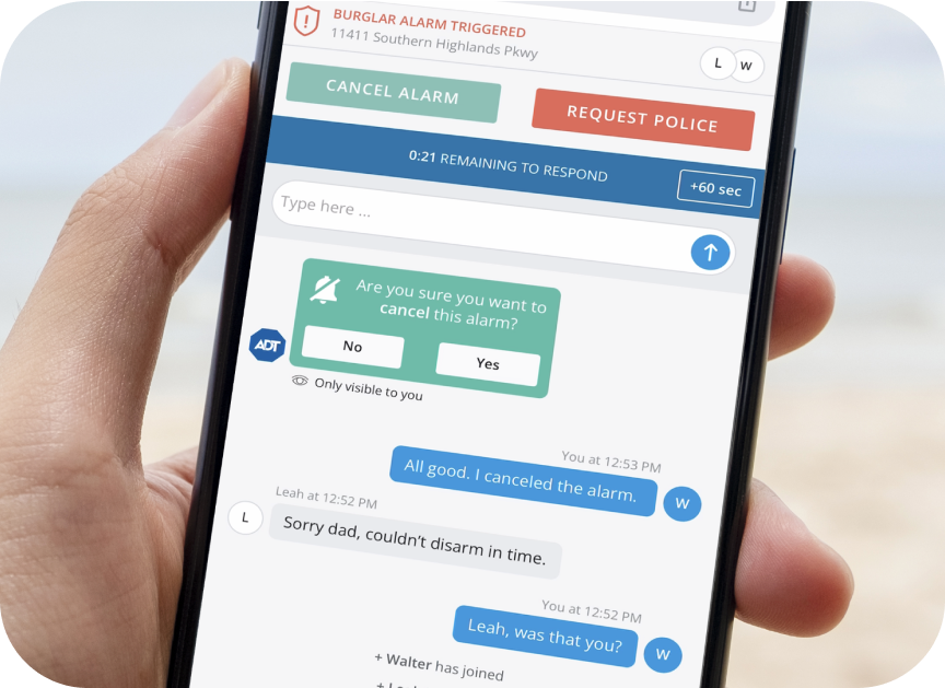 Hand holding a cell phone with the ADT Alarm Messenger app chat feature