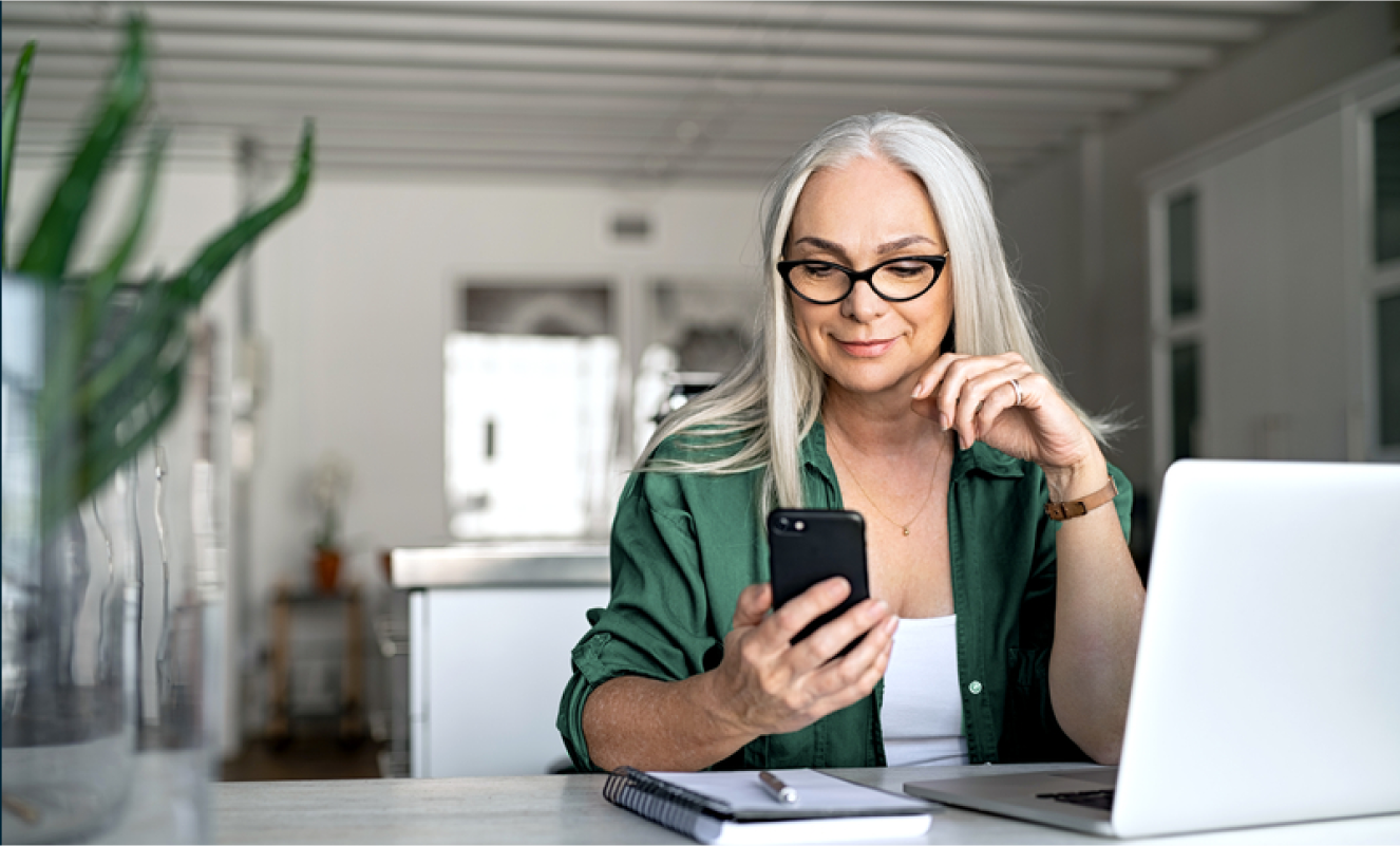 Woman looking at her ADT app on her phone in her home Woman looking at her ADT app on her phone in her home
